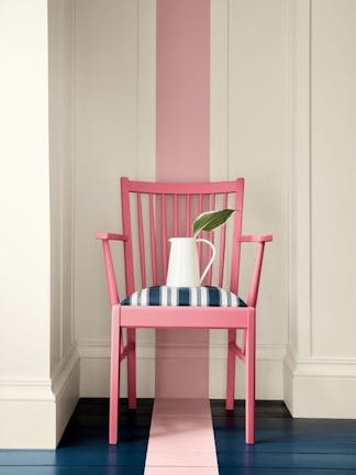 Pink chair with a pink stripe on the wall and floor