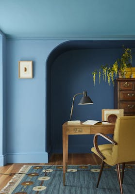 Home office space with an alcove painted in three shades of blue ('Woad', 'Tivoli' and 'Blue Verditer') with a wooden desk and chair.